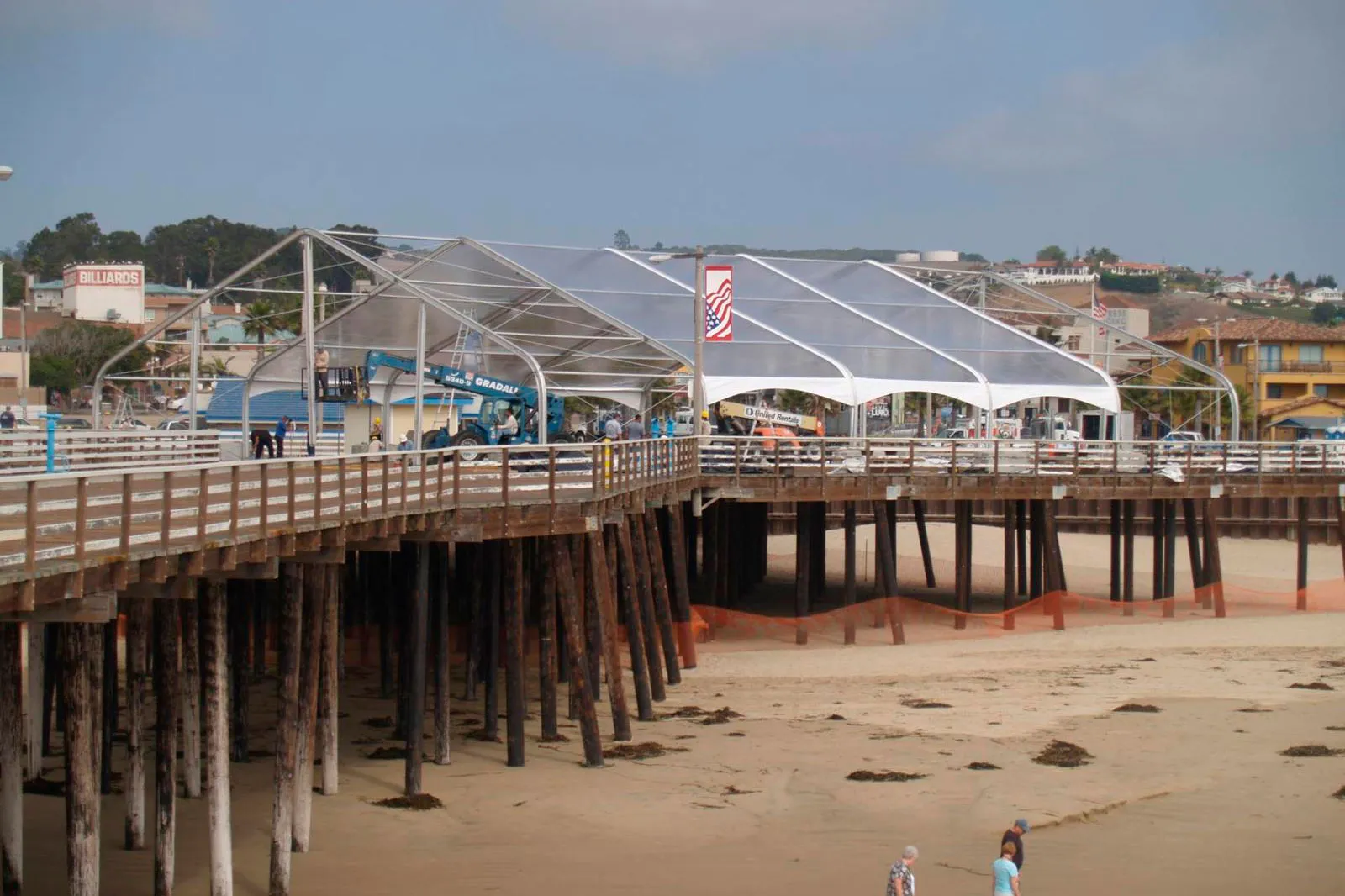 A clear-top structure erected on a wooden pier over the water.