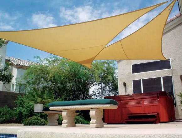 Tan shade sails stretched over a backyard patio.