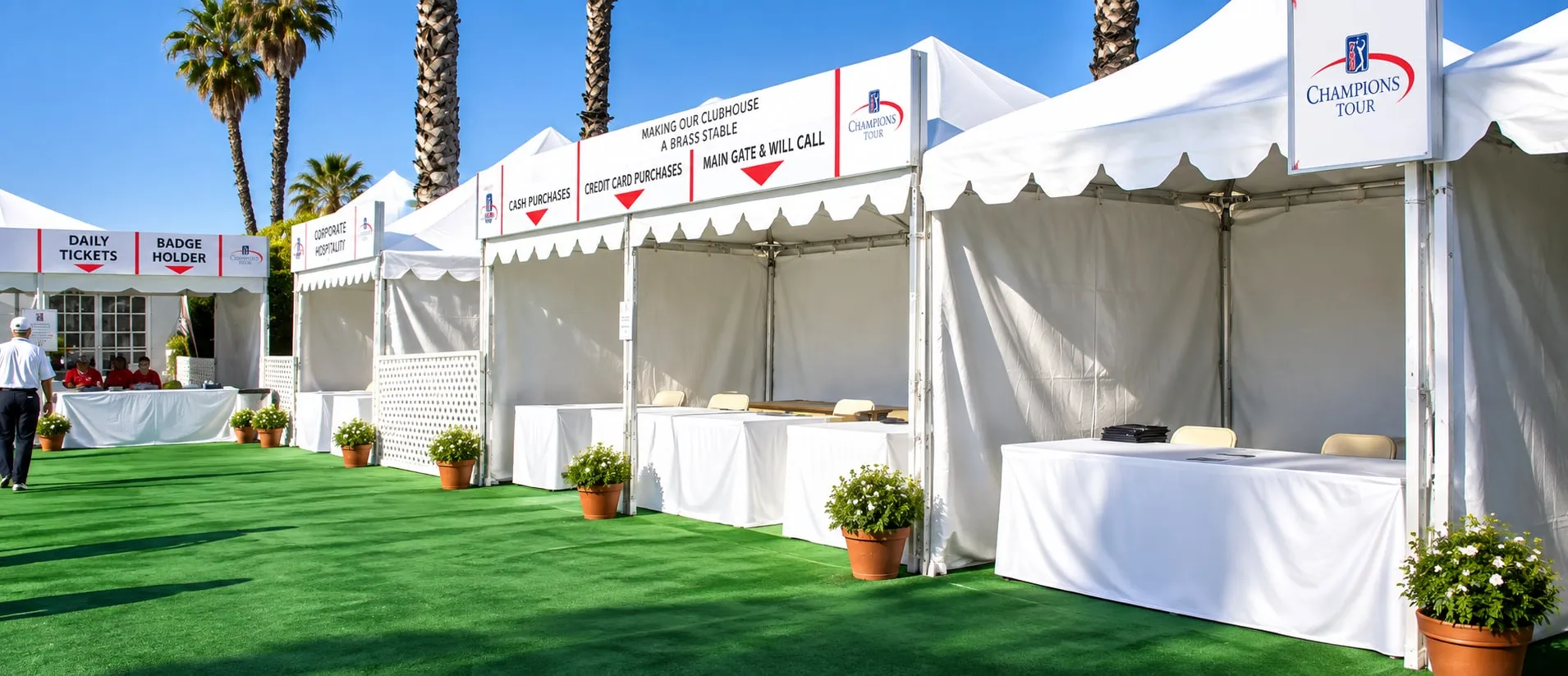 A white standard frame tent viewed from outside, showing the aluminum frame legs and the perimeter valance.