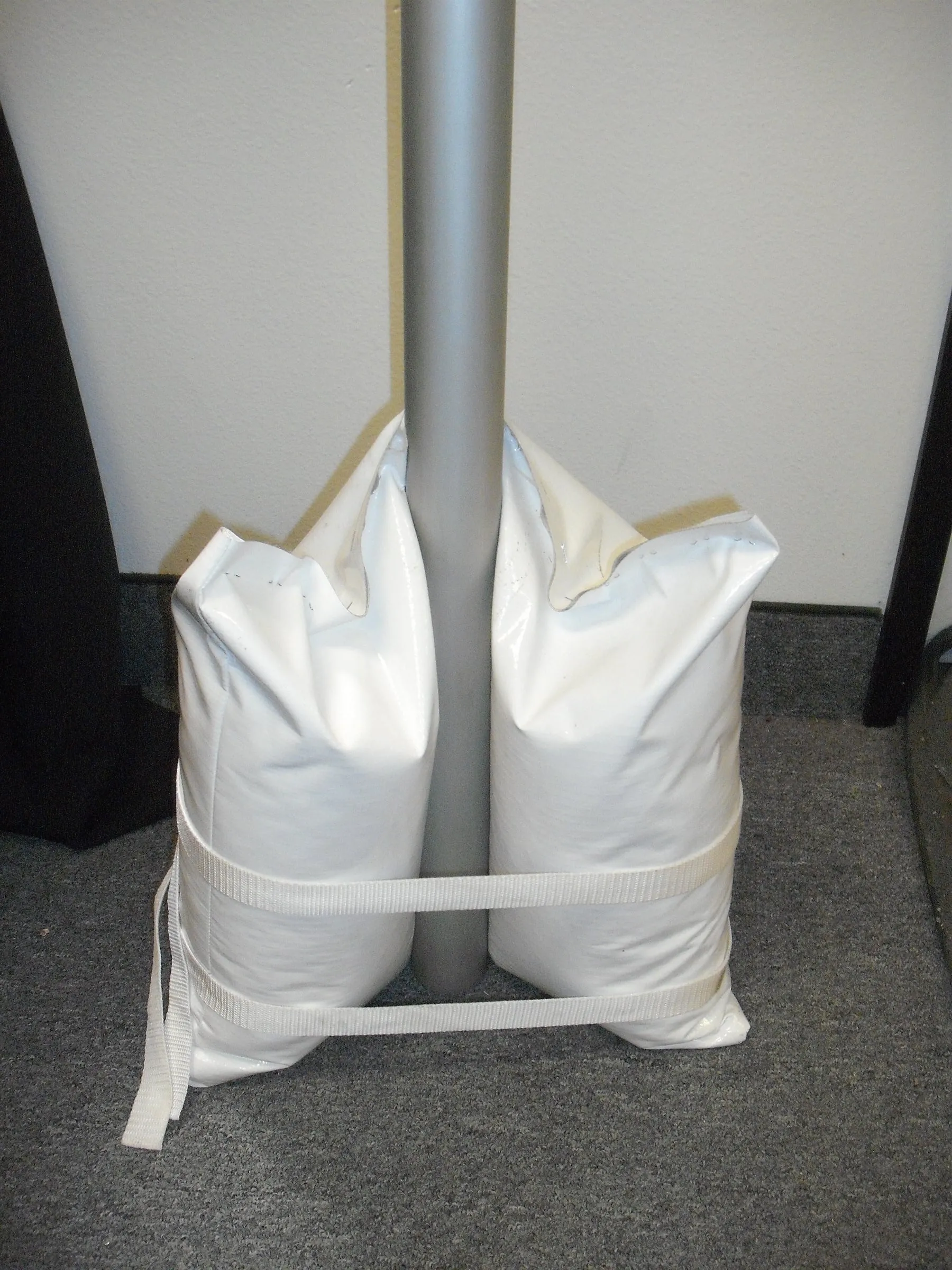 Sandbag weights strapped around a tent leg.